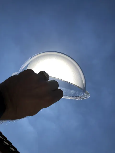 A coated disc against the sky.