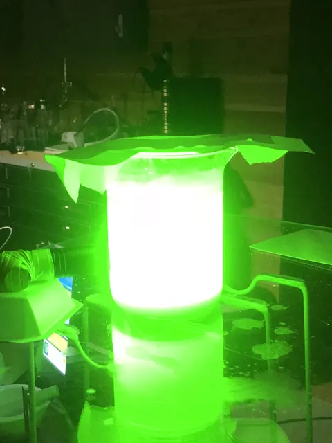 A cylinder lit green.