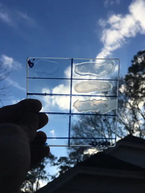 A coated glass sample held against the sky.