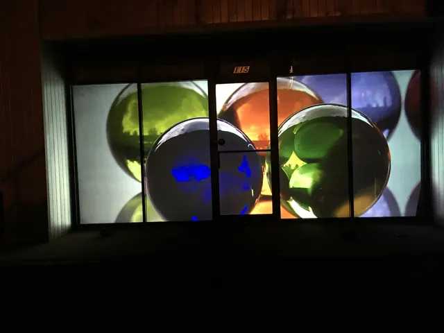 Rear projection onto storefront glass from inside the room.