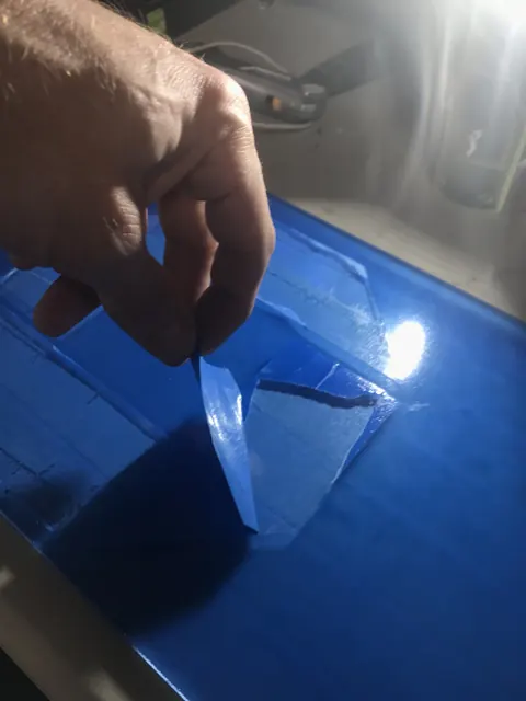 Brushing a coating onto film by hand.